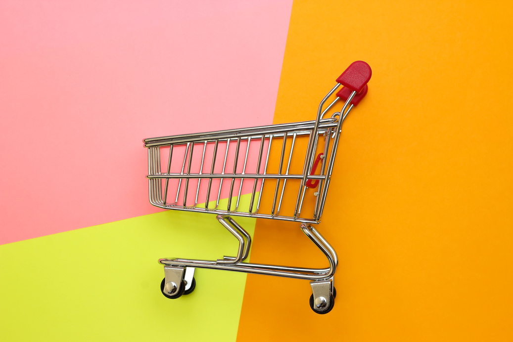Self-service supermarket full shopping trolley cart on colorful background